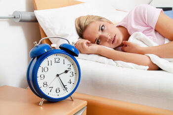 Frau nachts im Bett: Einschlafprobleme halten sie wach. 
